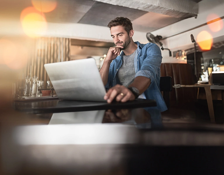 Vállalkozó férfi digitálisan intézi pénzügyeit a laptopján az új Vállalati InternetBank segítségével